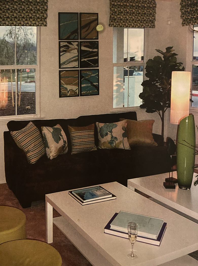 Artwork in a styled sitting area with a dark sofa