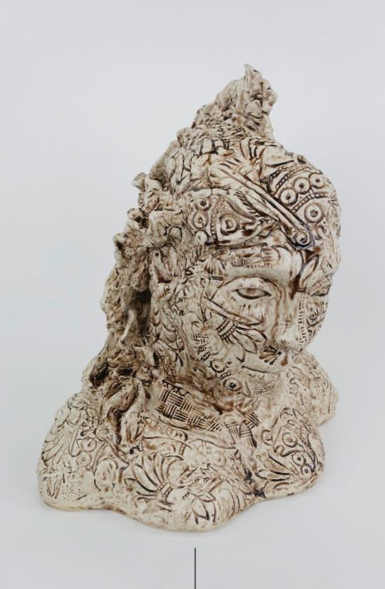 Ornately carved ceramic bust covered in intricate engraved patterns